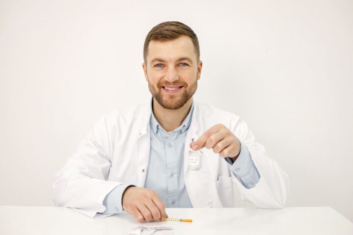male-doctor-holding-vaccine-against-covid19-isolated-white-background (1) (1)